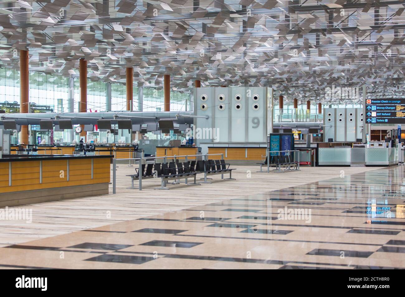 Departure hall terminal is swept clean of passenger as the pandemic continues to wreck damages to the aviation industry. Changi Airport, Singapore. Stock Photo