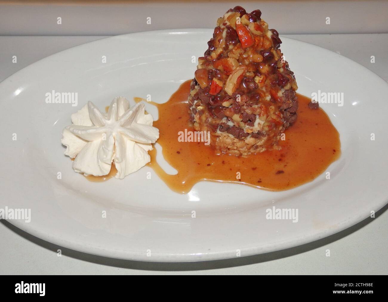 A nut and chocolate stack dessert with a little whipped cream.. Stock Photo