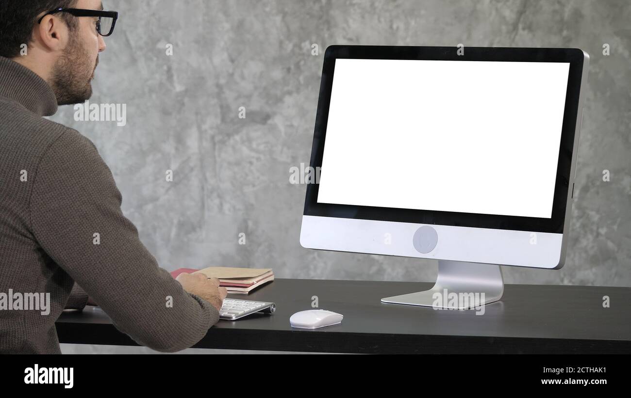 Elegant businessman analyzing data in office on his computer. Ba Stock Photo