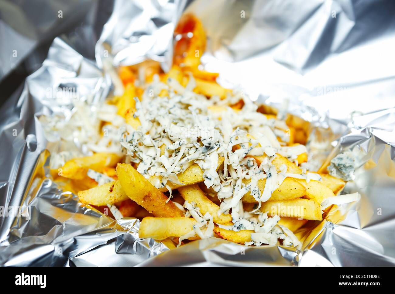 Gourmet French fries with melted cheese served in tin foil