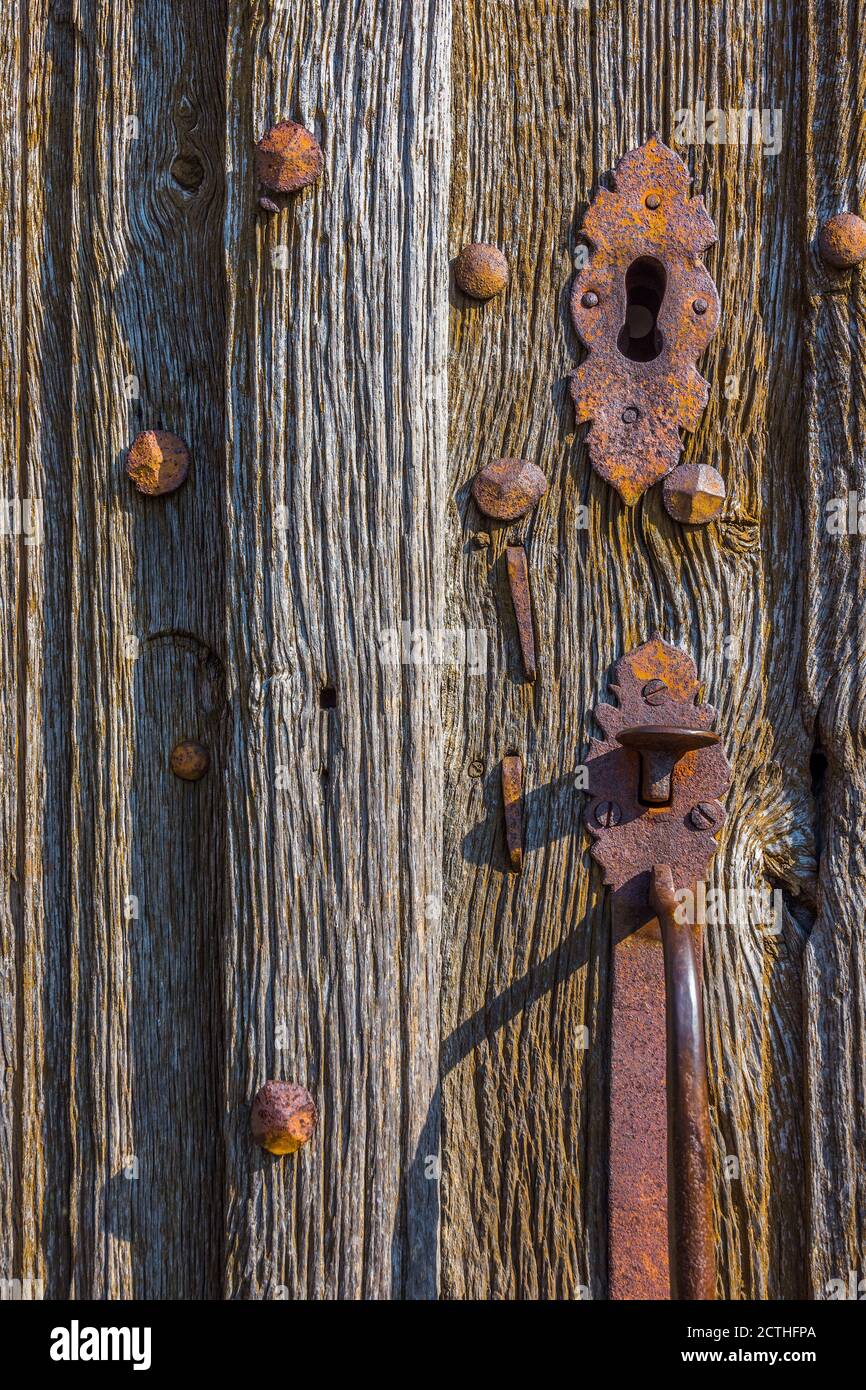 Old metal handle on weathered oak church doors - Oradour-Saint-Genest, Haute-Vienne (87), France. Stock Photo