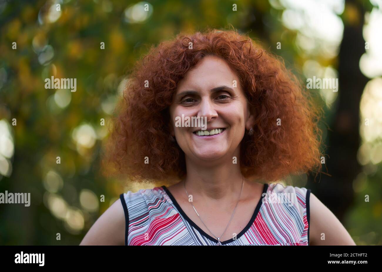 Curly redhead woman outdoor in the countryside, candid portrait Stock ...