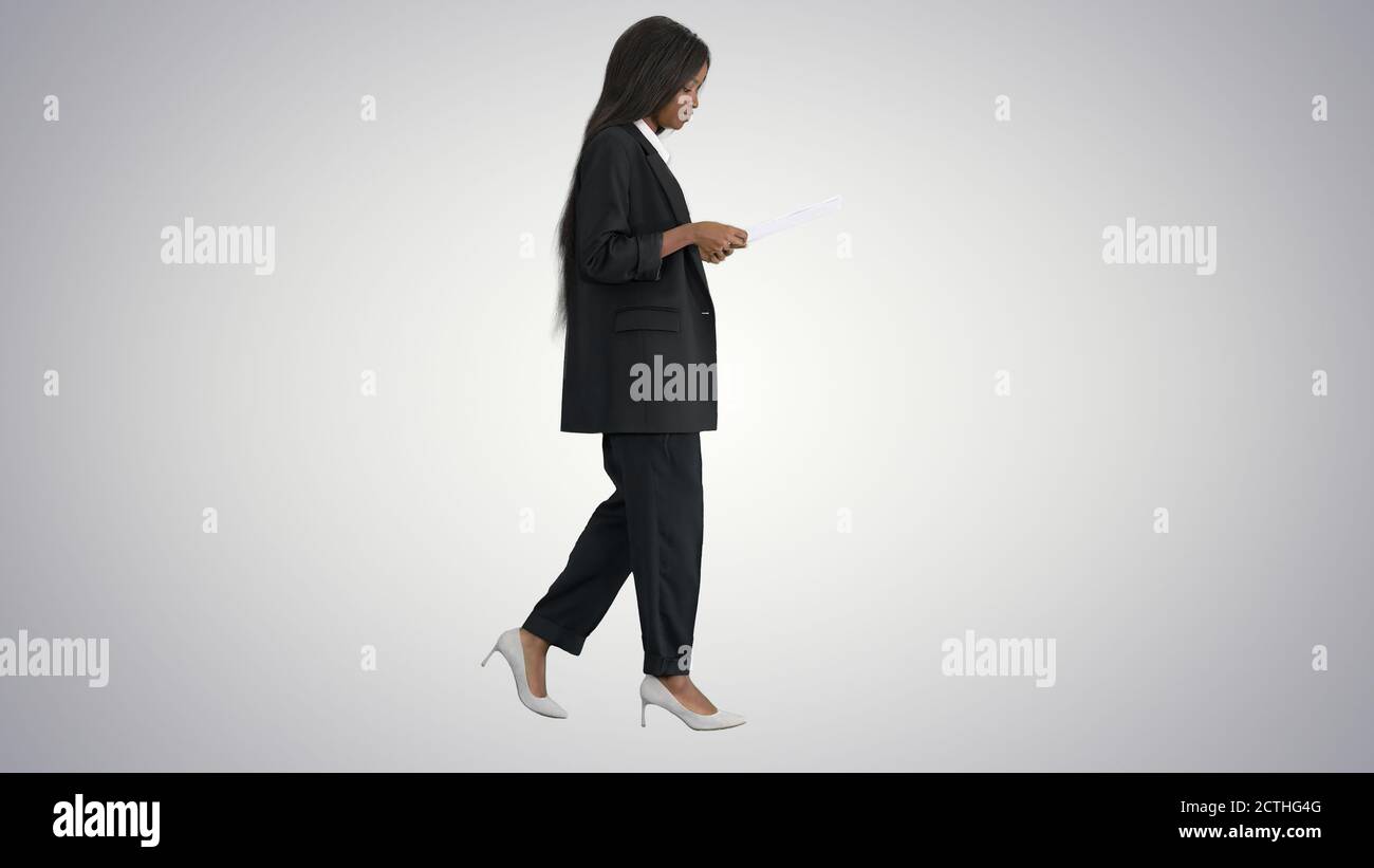 Serious african american woman reading documents while walking o Stock Photo