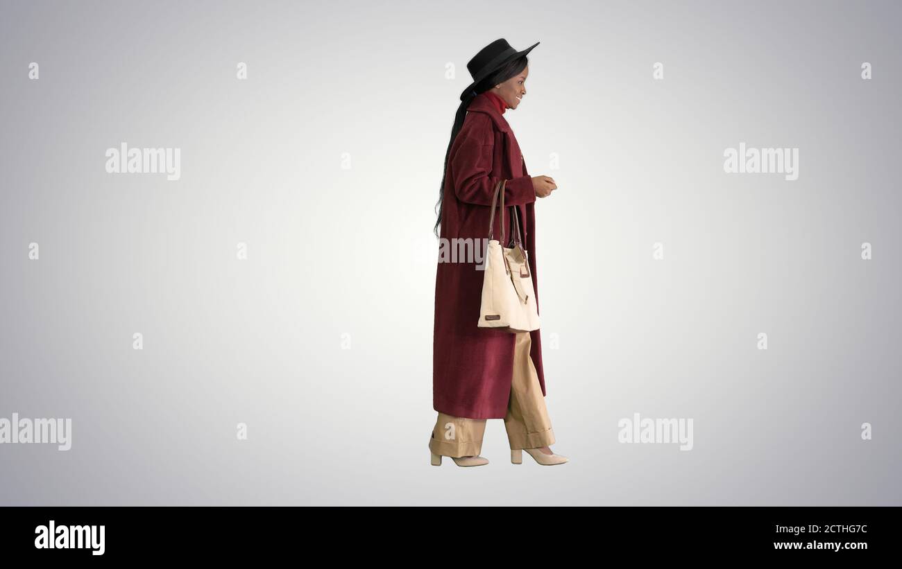 Beautiful african american woman walking on gradient background. Stock Photo