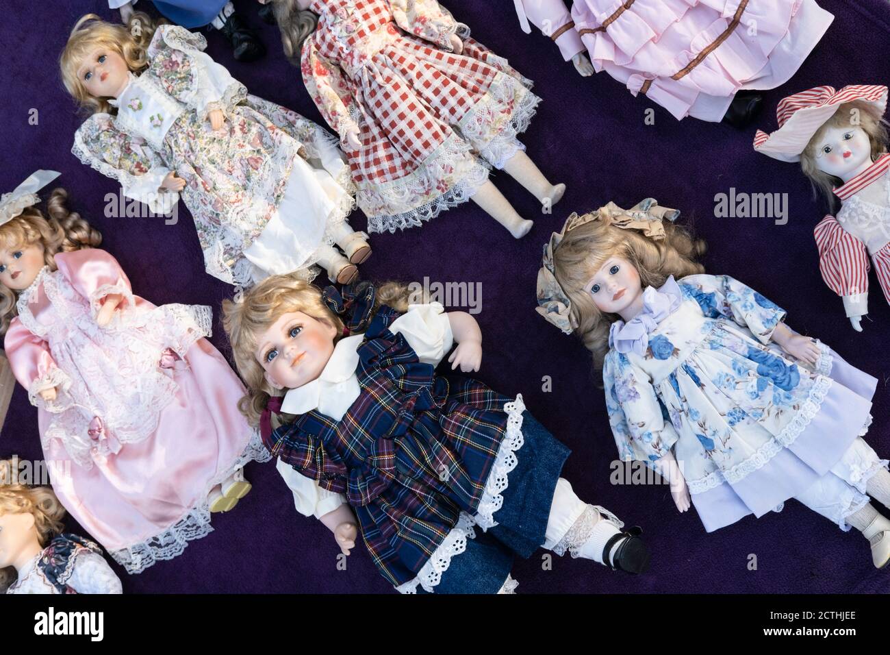 Beautifully dressed lifelike porcelain dolls lie on a table for sale on an antique market in Tongeren, Belgium Stock Photo