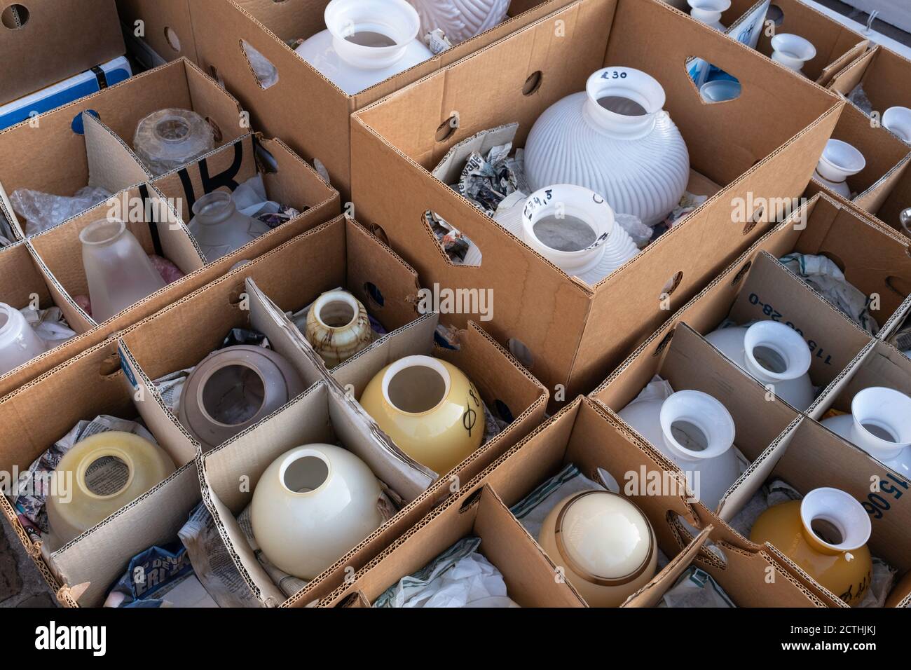 Cardboard boxes with various old, retro and new glass lampshades in all kinds of colors and shapes for sale at an antique market in Tongeren, Belgium Stock Photo