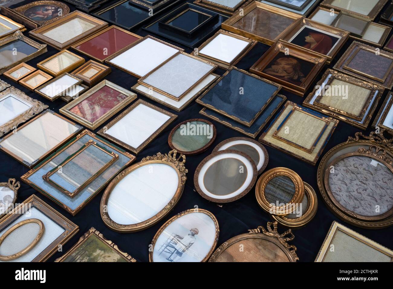 Older round, square, oval and rectangular photo and picture frames and mirrors for sale on an antique market in Tongeren, Belgium Stock Photo