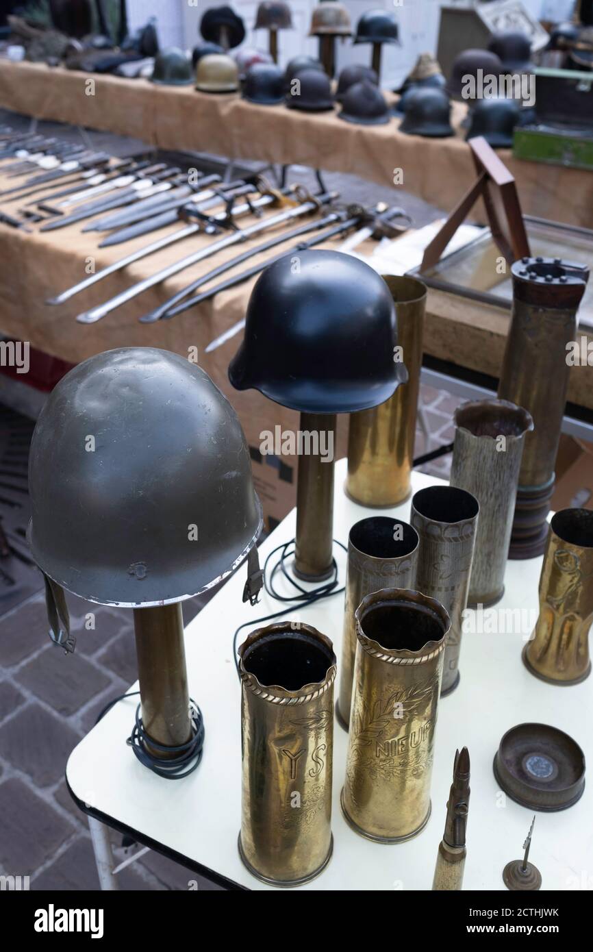 All kinds of war equipment such as bullet casings, swords and helmets for sale on an antique market in Tongeren, Belgium Stock Photo