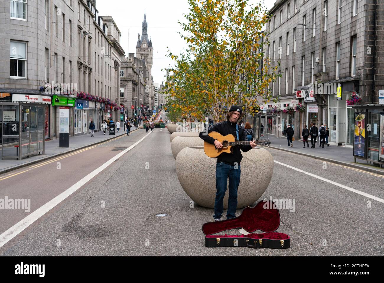 View of musician busking on pedestrianised Union Street in Aberdeen city centre, Scotland, UK Stock Photo