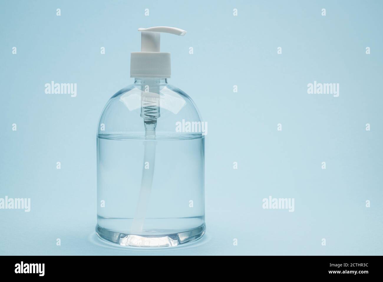 Dispenser of antibacterial gel on blue background Stock Photo