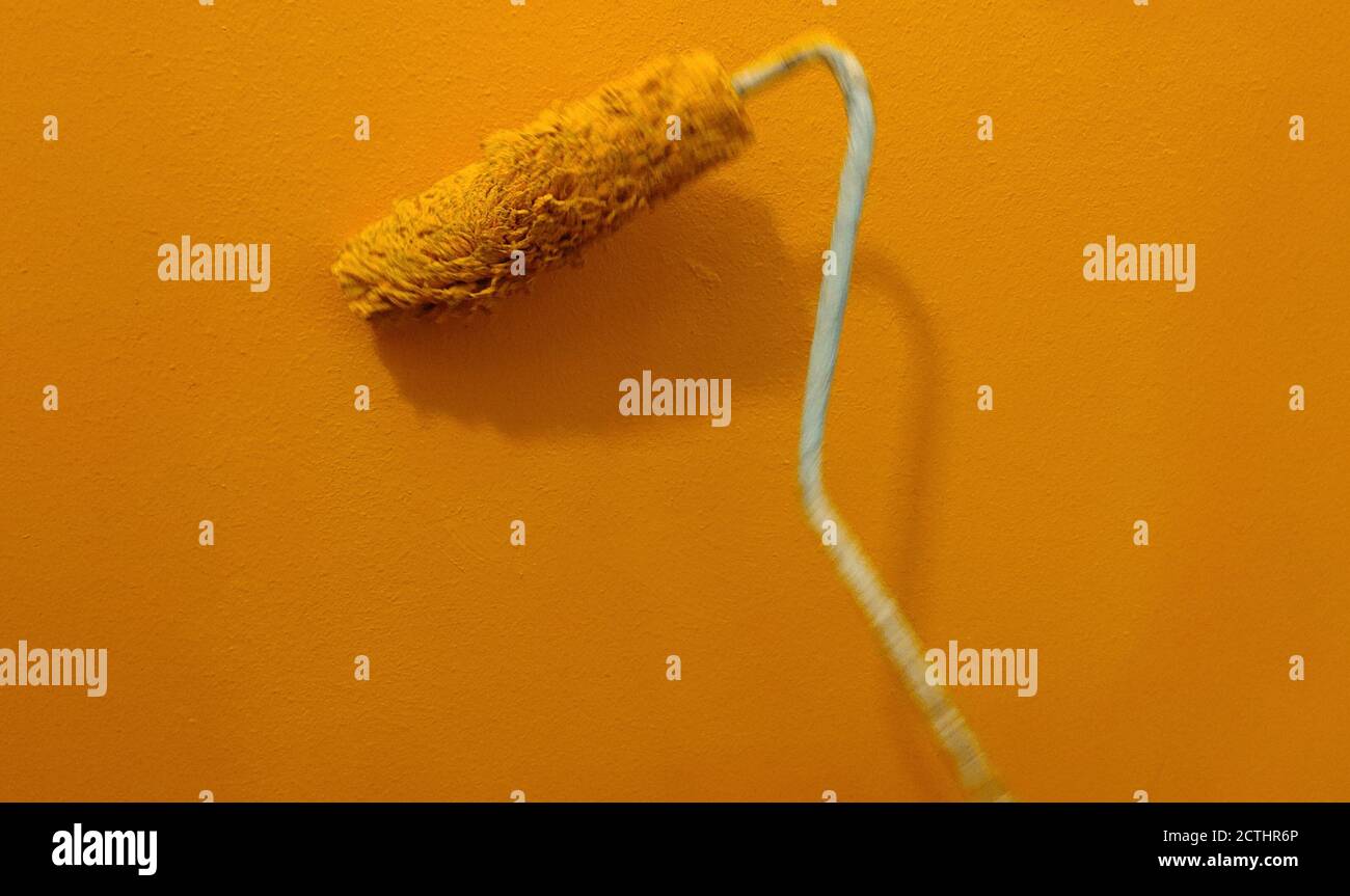 In motion paint roller against the wall Stock Photo