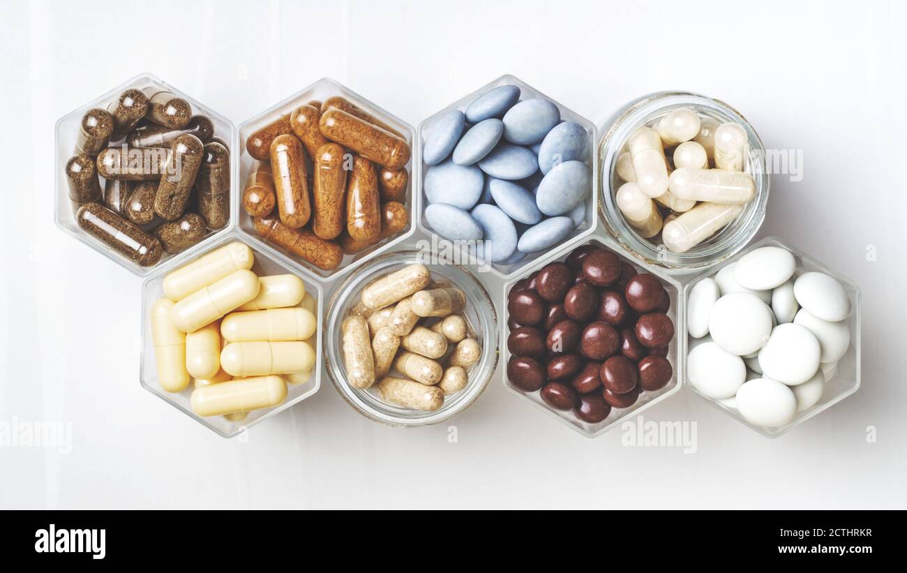 Various medical capsules and tablets in hexagonal jars in the form of ...