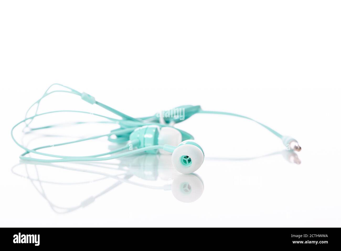 Light green color earphone selective focus isolated on white backdrop copy space Stock Photo