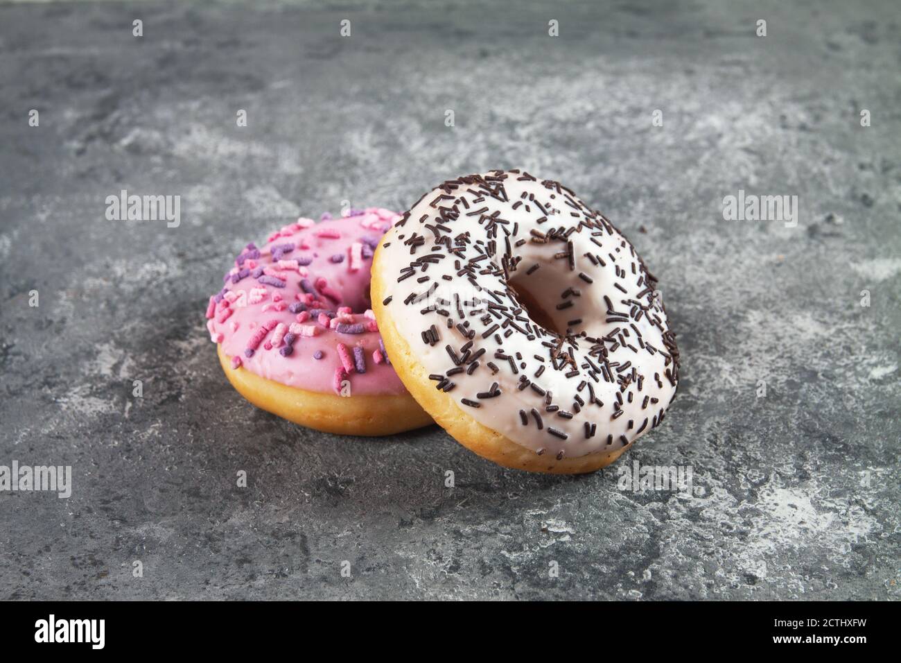 Baked sweet delicious donuts with pastry crumb on gray concrete ...