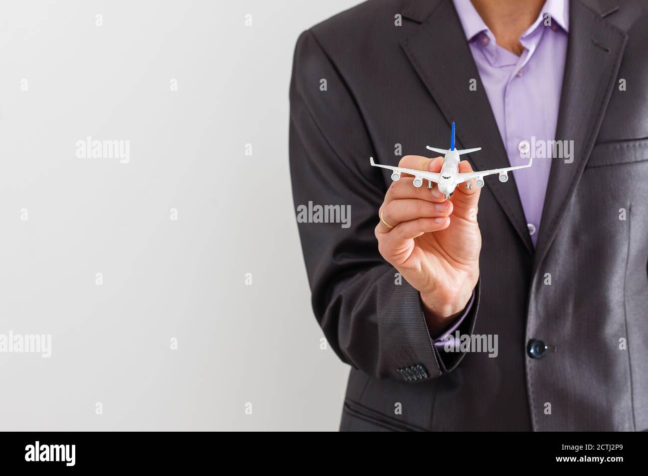 Adult businessman in suit holding a plane isolated on white Stock Photo
