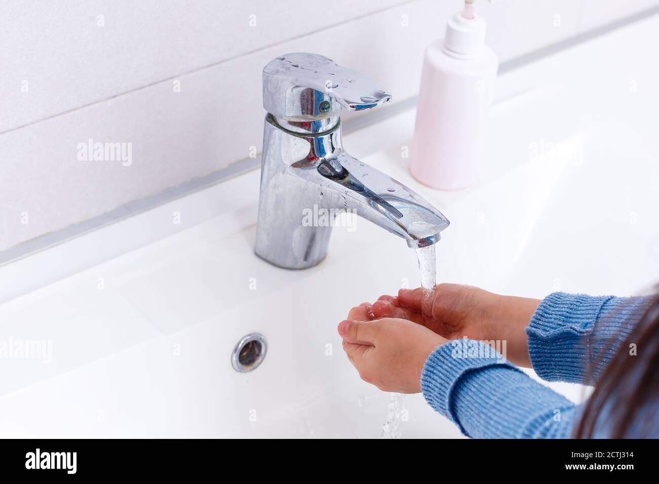 Little girl is washing her hands in the bathroom Stock Photo - Alamy