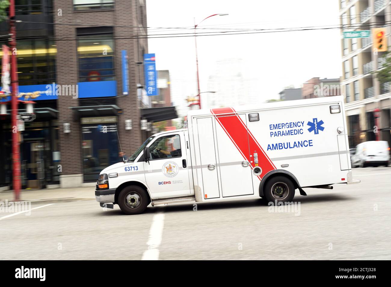 An emergency paramedic ambulance rushes to an incident scene along Main Street in Vancouver, British Columbia, Canada Stock Photo