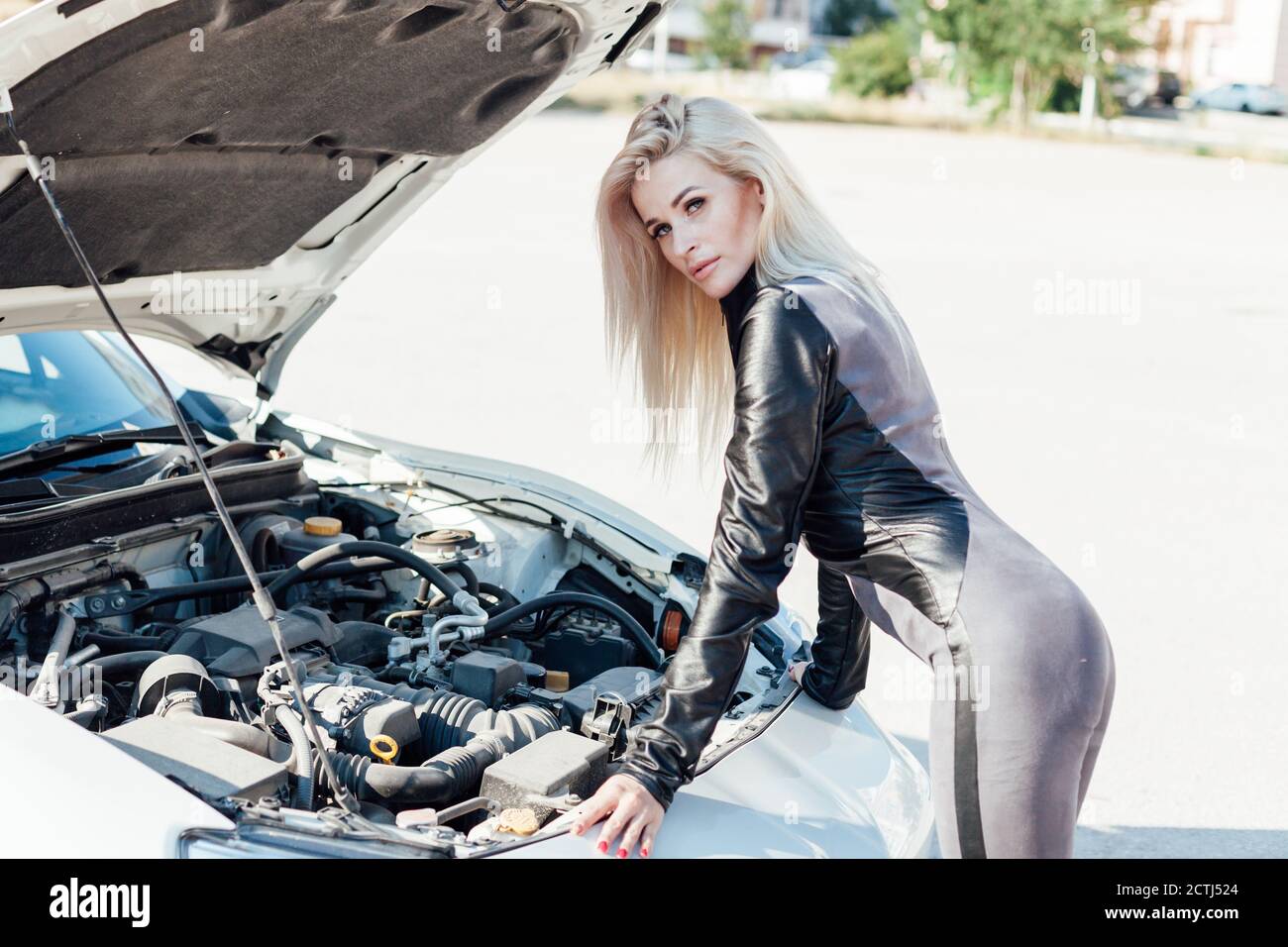 Beautiful female blonde mechanic repairs car engine Stock Photo - Alamy