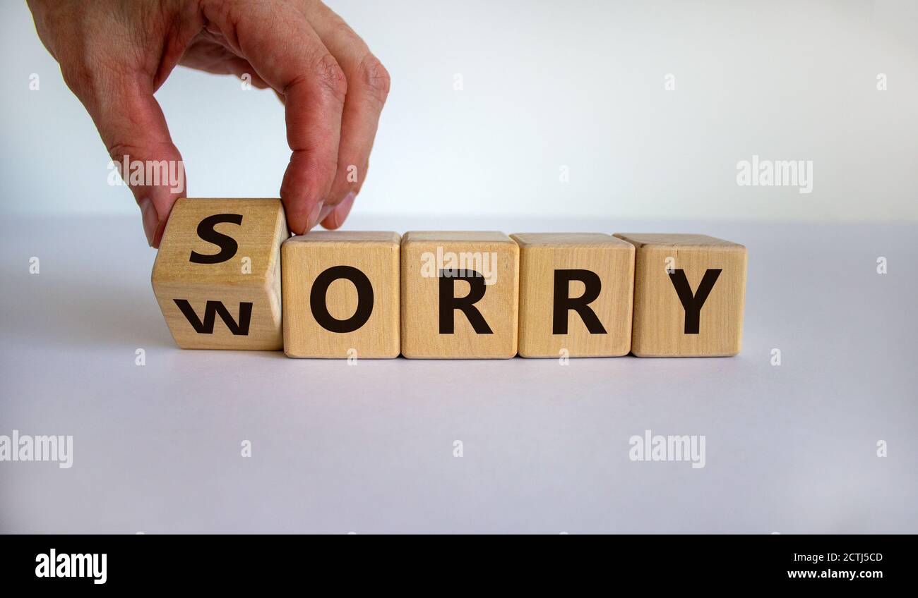 Sorry to worry. Hand turns a cube and changes the word 'worry' to 'sorry'. Beautiful white background. Business concept, copy space. Stock Photo