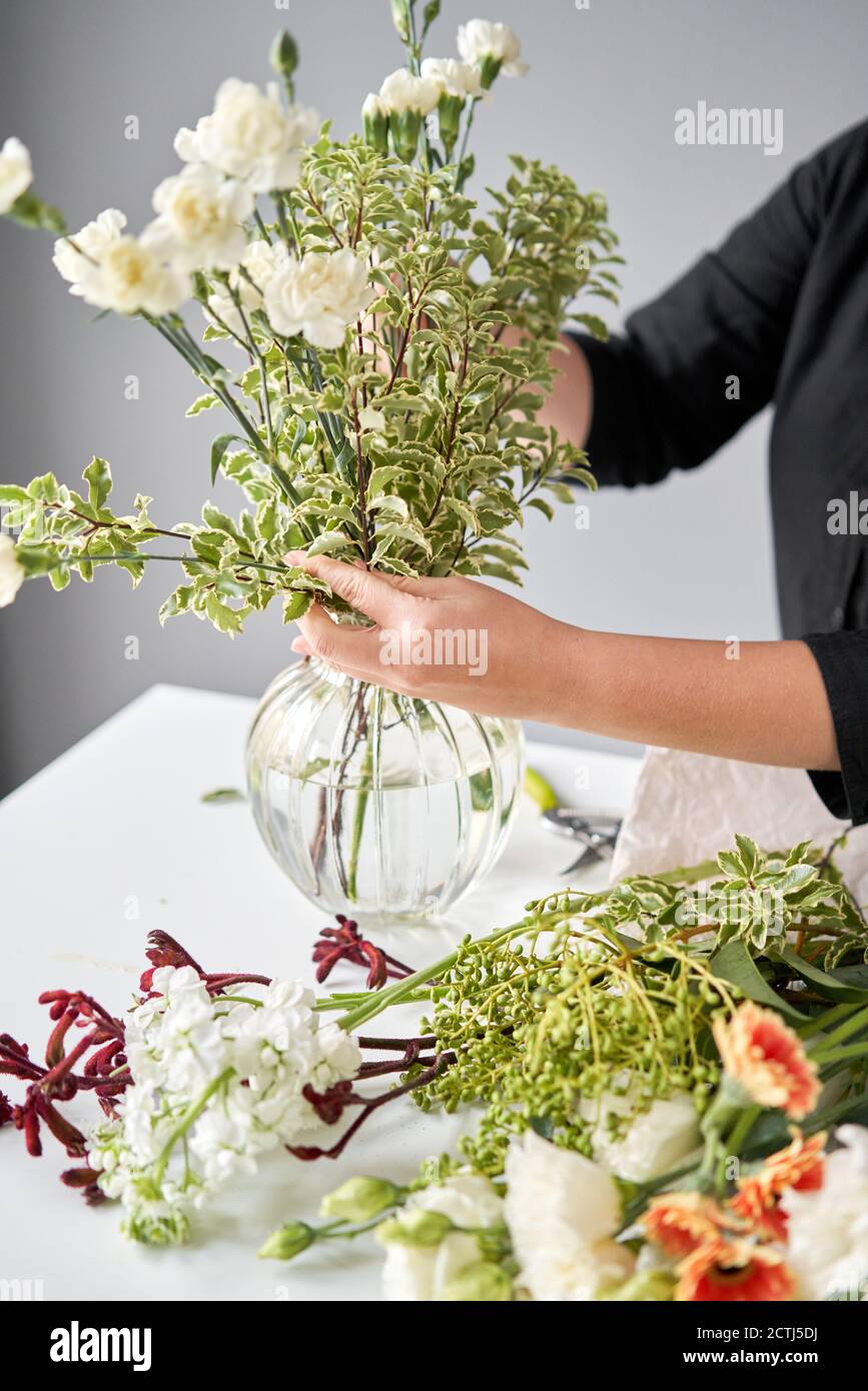 Series, step by step installation of flowers in a vase. Flowers bunch, set for home. Fresh cut flowers for decoration home. European floral shop Stock Photo