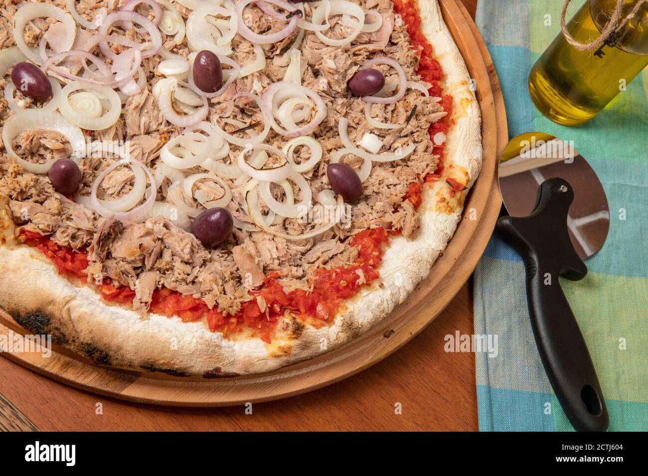Pizza tuna fish, onion, tomato and black olive on wooden table. Traditional Brazilian Pizza