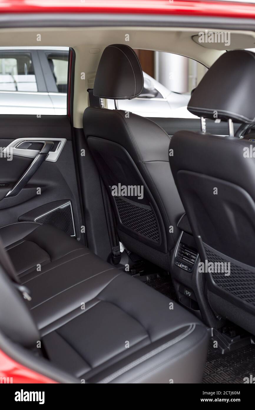 Russia, Izhevsk - August 14, 2020: Geely showroom. Back passenger seats and black leather driver seat inside Atlas car with seat belts. Famous brand. Stock Photo