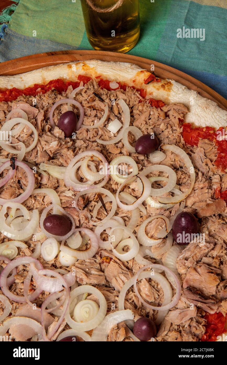 Pizza tuna fish, onion, tomato and black olive on wooden table. Traditional Brazilian Pizza. Stock Photo