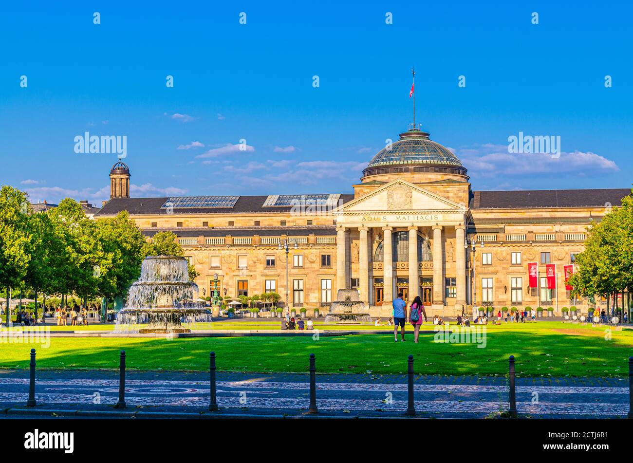 Wiesbaden, Germany, August 24, 2019: Kurhaus or cure house spa and casino building and Bowling Green park with grass lawn, trees alley and pond with fountain in historical city centre, State of Hesse Stock Photo