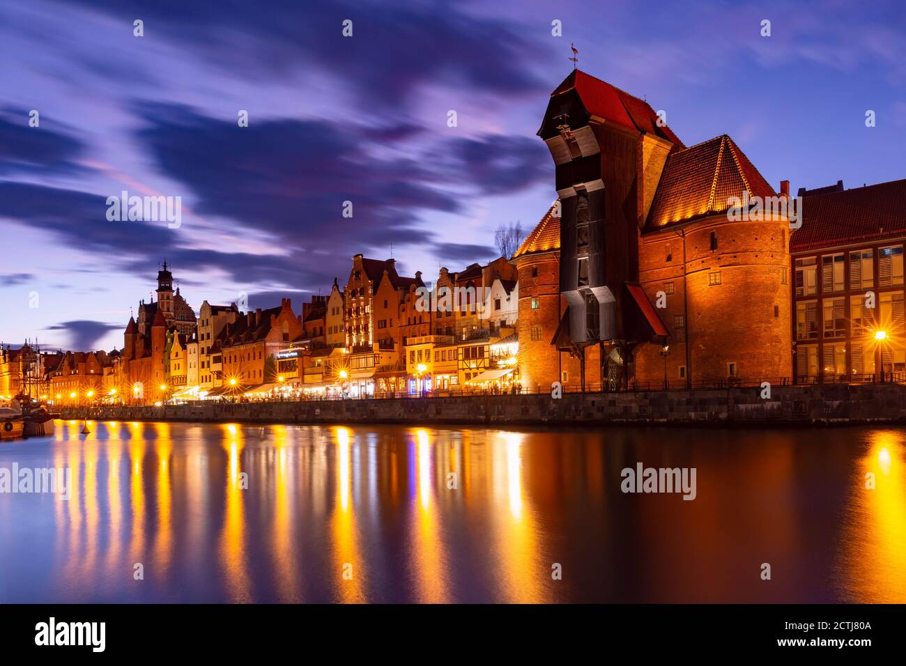 Old harbour crane and city gate Zuraw in old town of Gdansk at night, Poland Stock Photo