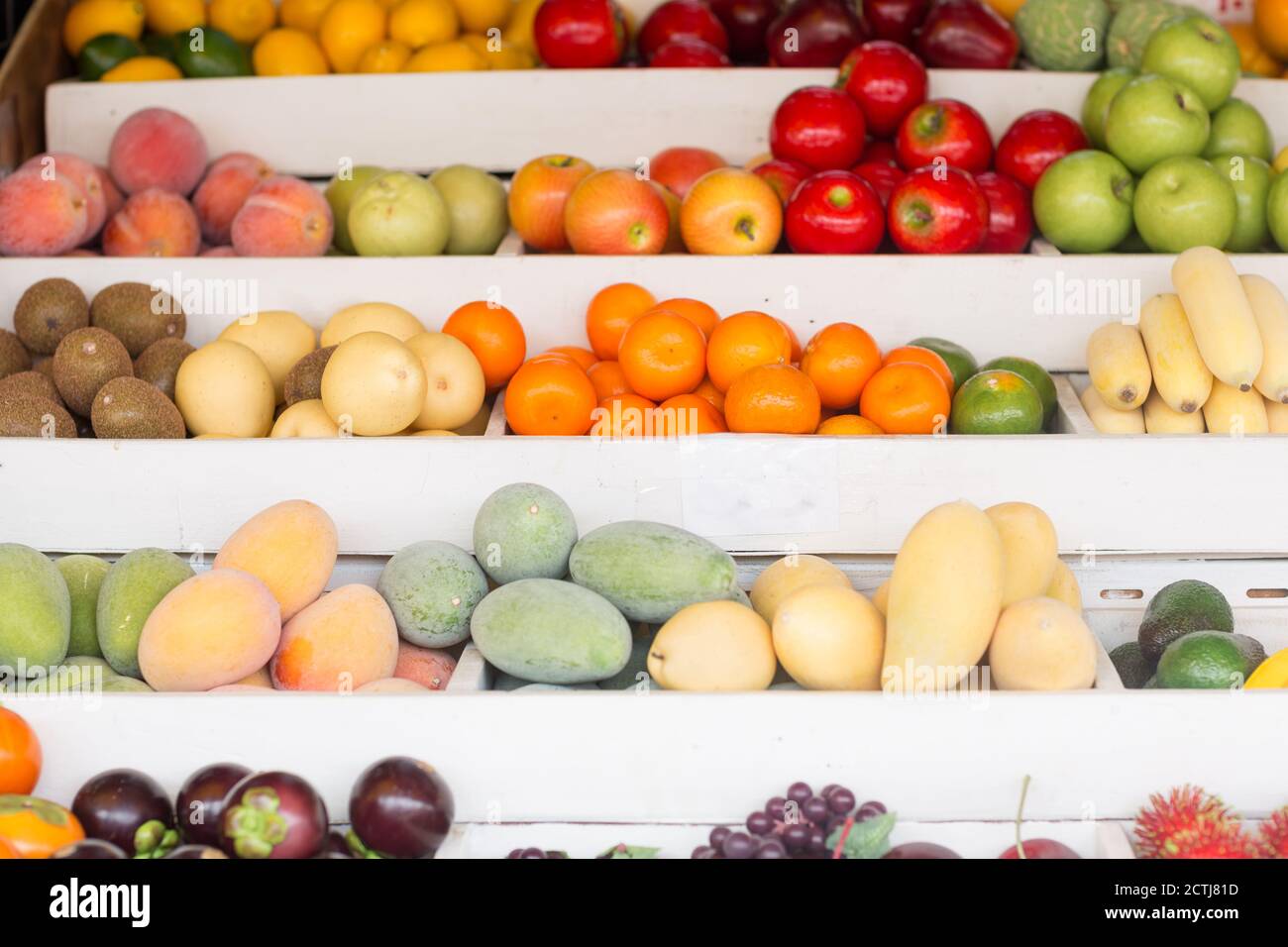 Many fresh season fruits for sale displayed on a stand at a local farmers market. Stock Photo