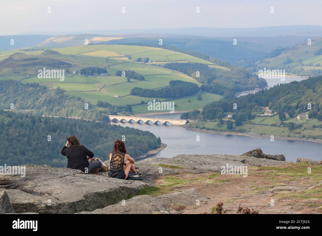 Two walkers sit and admire the view over Ladydower Reservoir on a day of uncertainty as the government consider putting the UK back into lockdown due to a spike in Covid 19 cases. Stock Photo