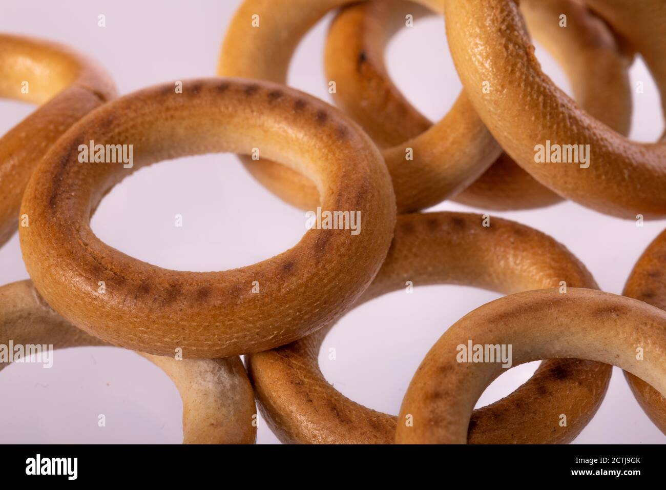 Macro shot of bagels on light background. Bakery products, dense bread rolls Stock Photo