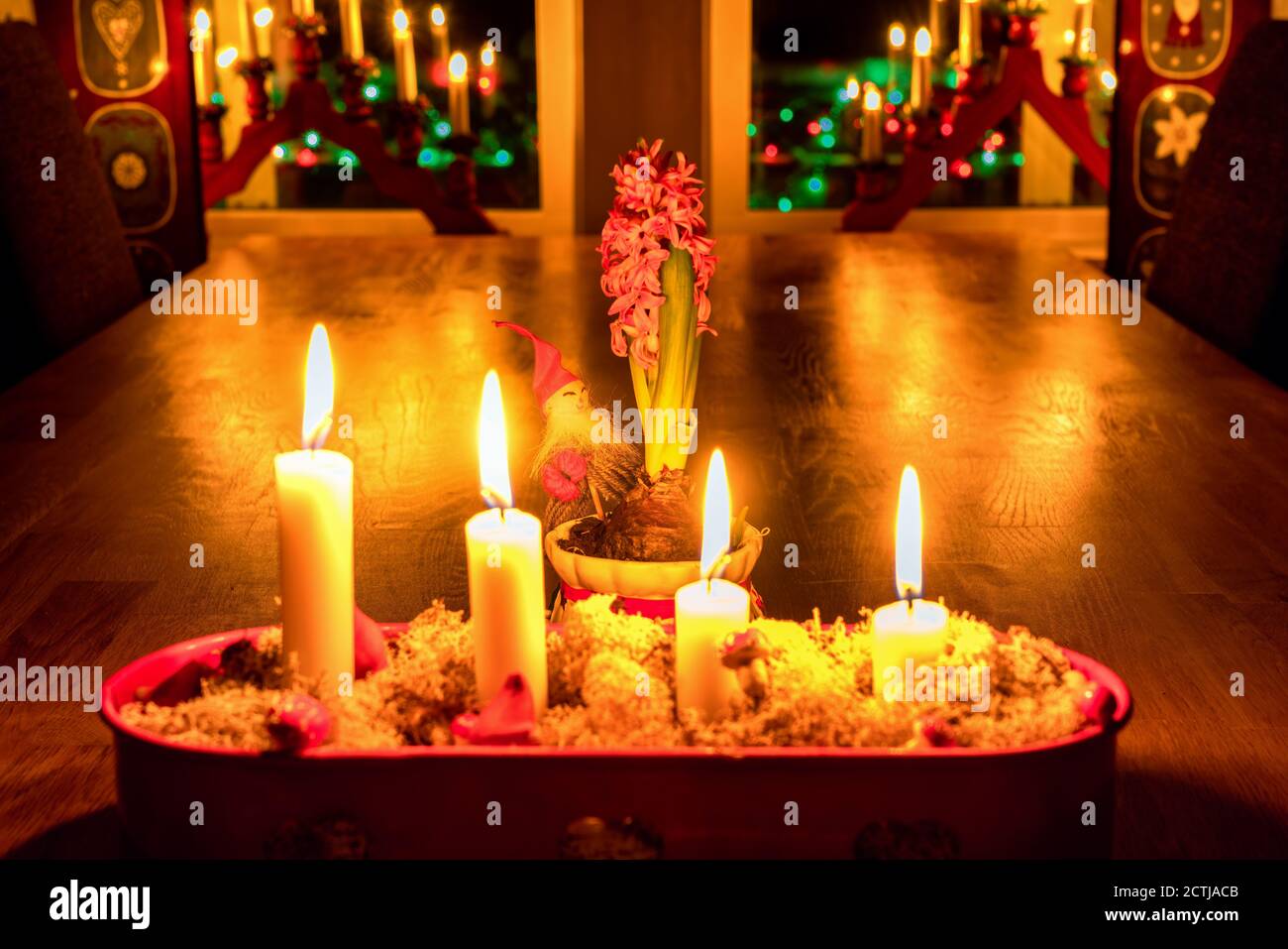 Burning Advent candles, red candlestick, oak table, close view Christmas  Eve. Traditional decoration in Swedish house with window lights, hyacinth  flo Stock Photo - Alamy