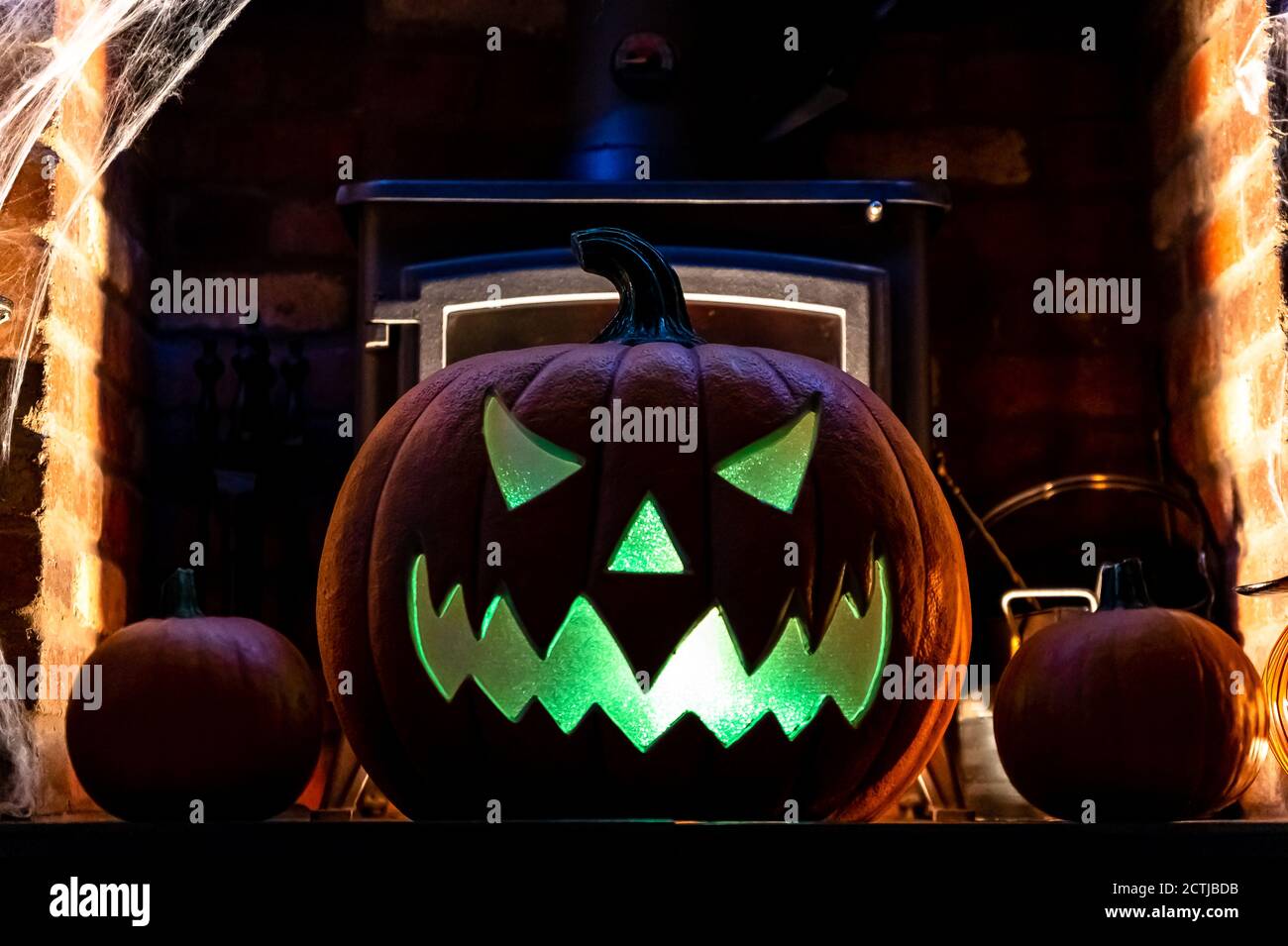 Large Halloween Pumpkin on Fireplace infront of fire. blue light on ...