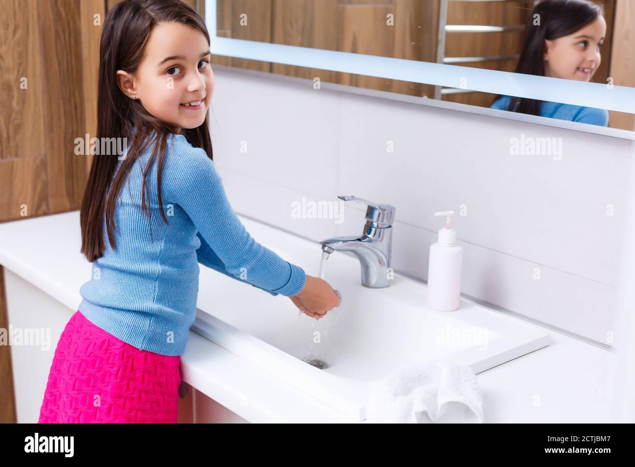 Little girl is washing her hands in the bathroom Stock Photo - Alamy
