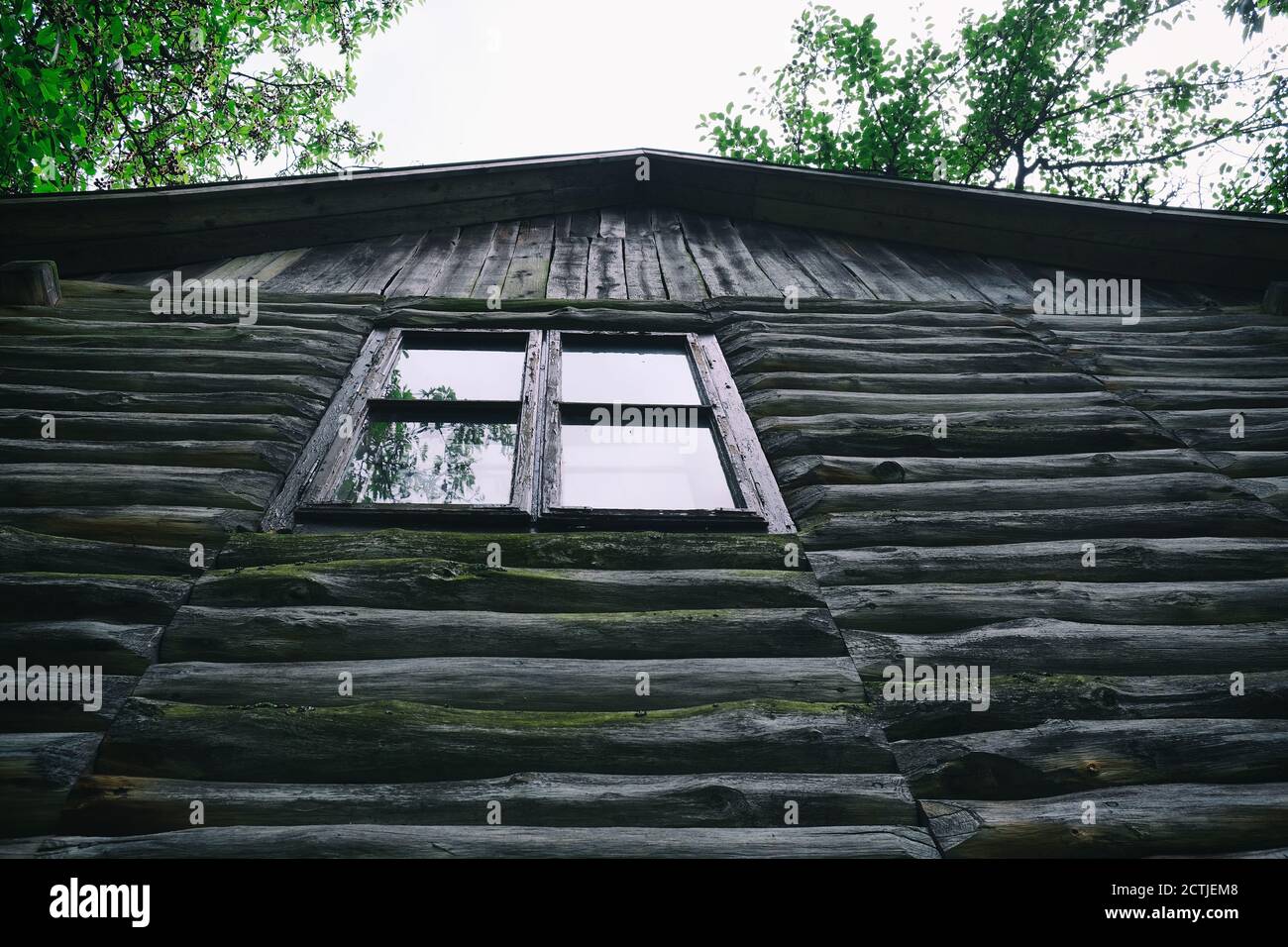 Old log house top of wooden planks with a wooden window Stock Photo