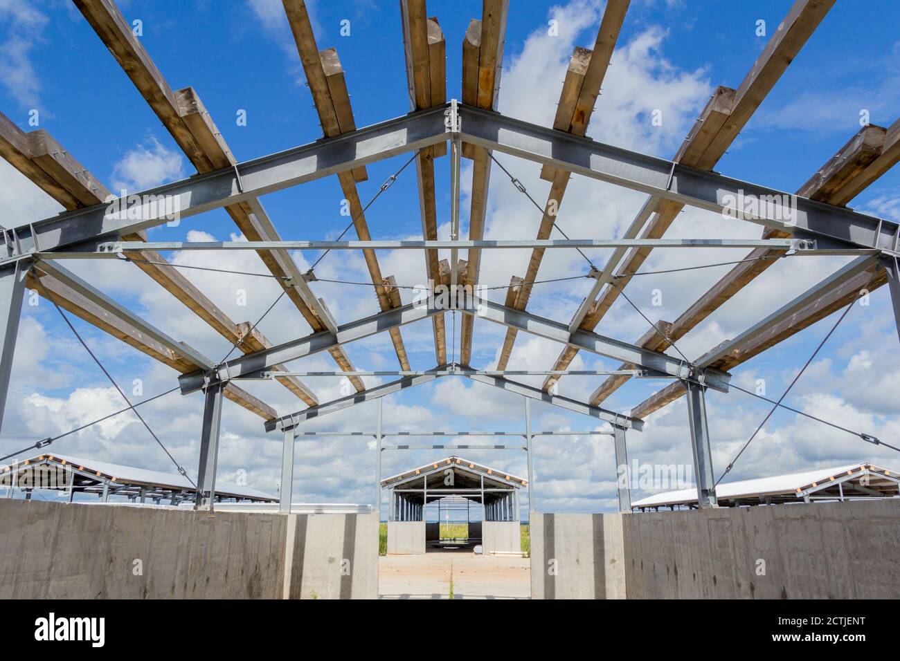 The roof design. Wooden beams on a steel frame. Steel frame of a building under construction. Stock Photo