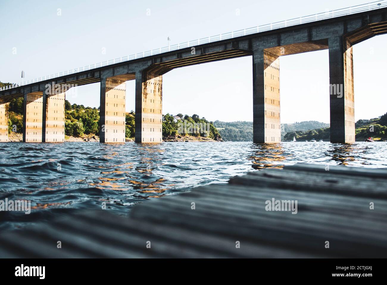 wooden board floating in the river against bridge Stock Photo - Alamy