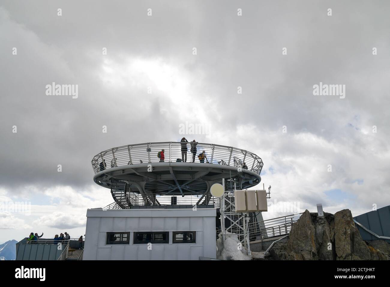 People on the panoramic terraces at Pointe Helbronner station of Skyway Monte Bianco cableway against cloudy sky, Courmayeur, Aosta, Italy Stock Photo