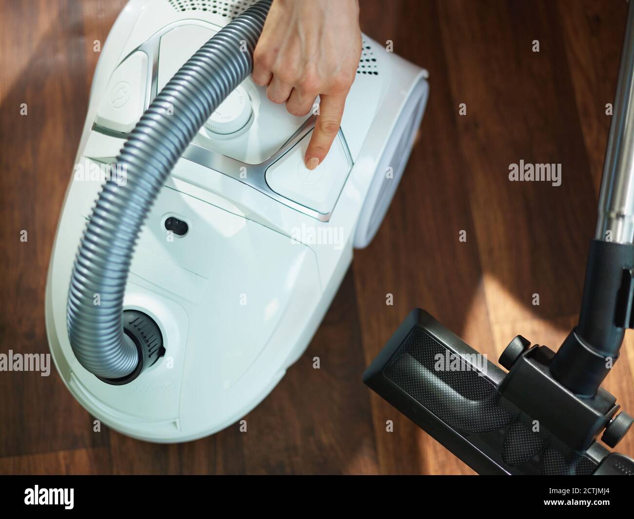 Closeup on woman with vacuum cleaner turning off at home in sunny day Stock Photo Alamy