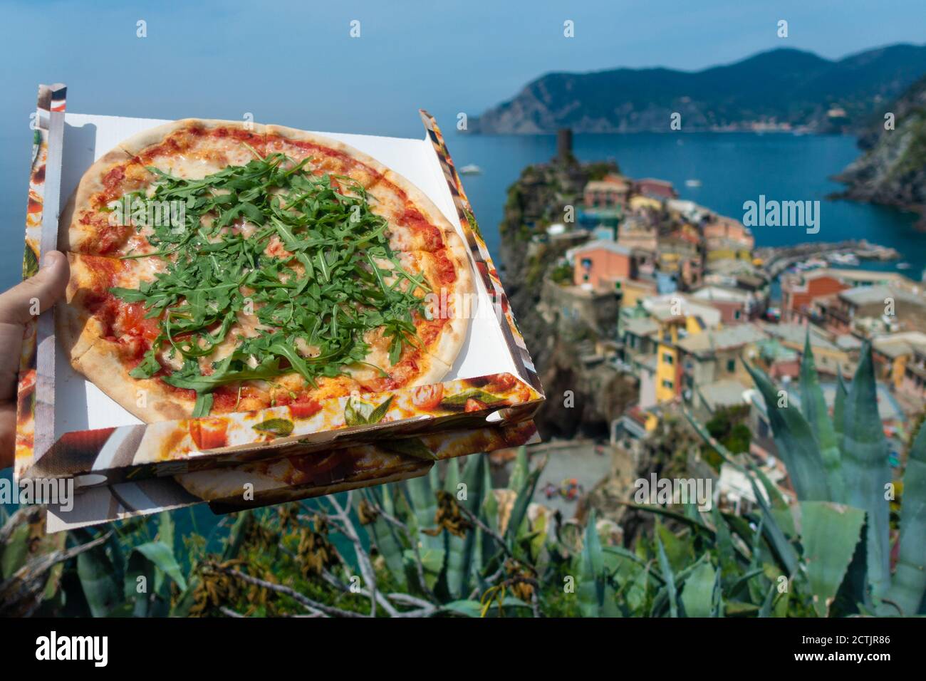 Hand holding a pizza box in Vernazza, Cinque Terre, Italian pizza wallpaper, Italy Stock Photo