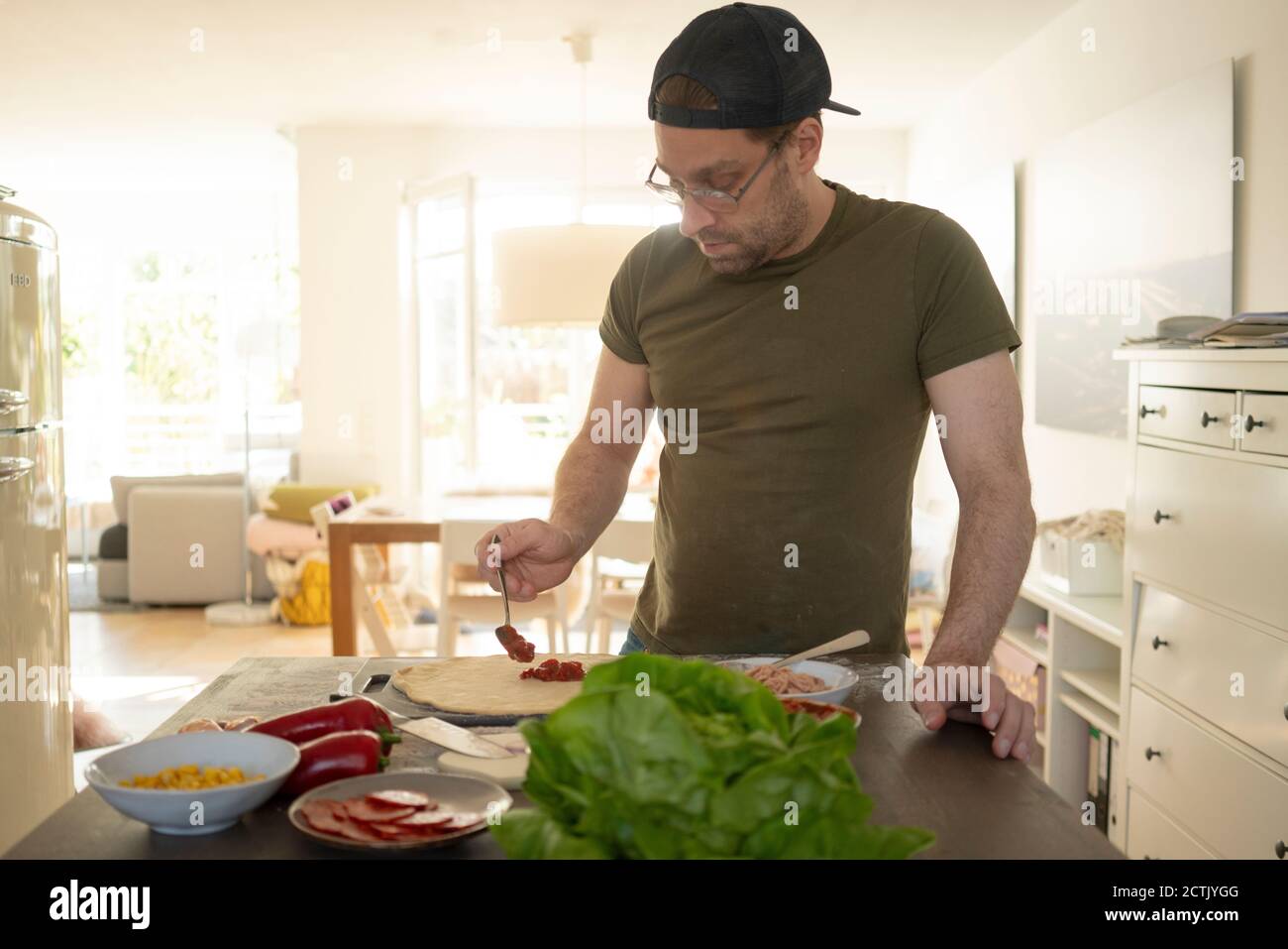 Man preparing pizza over kitchen island Stock Photo