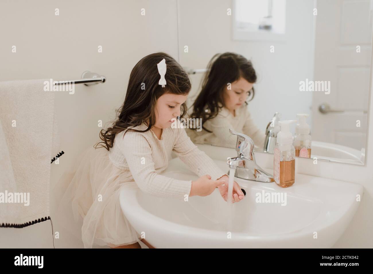 Girl washing hands in bathroom Stock Photo - Alamy
