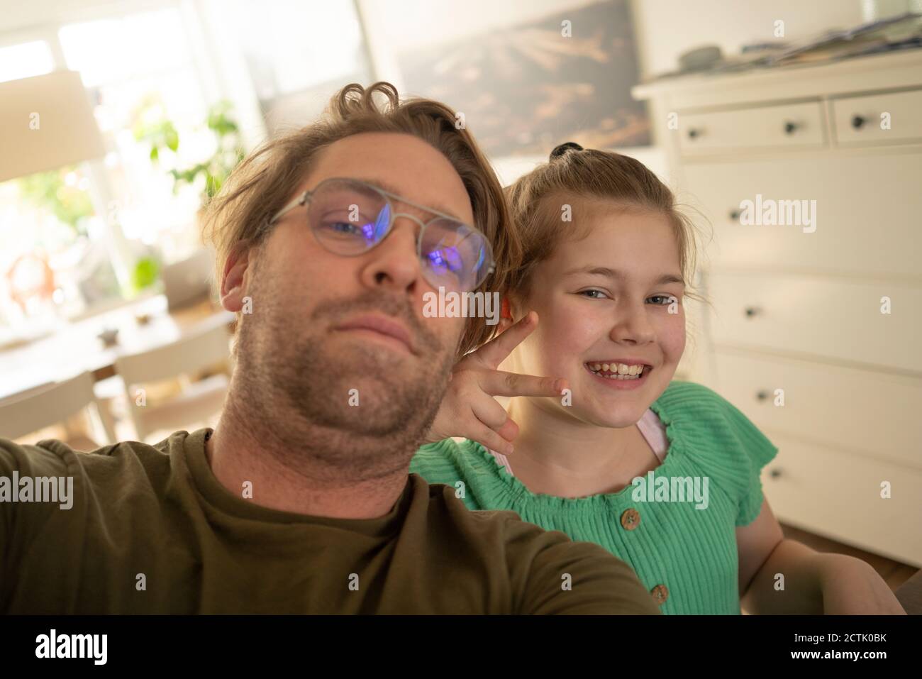 Smiling girl gesturing with father at home Stock Photo
