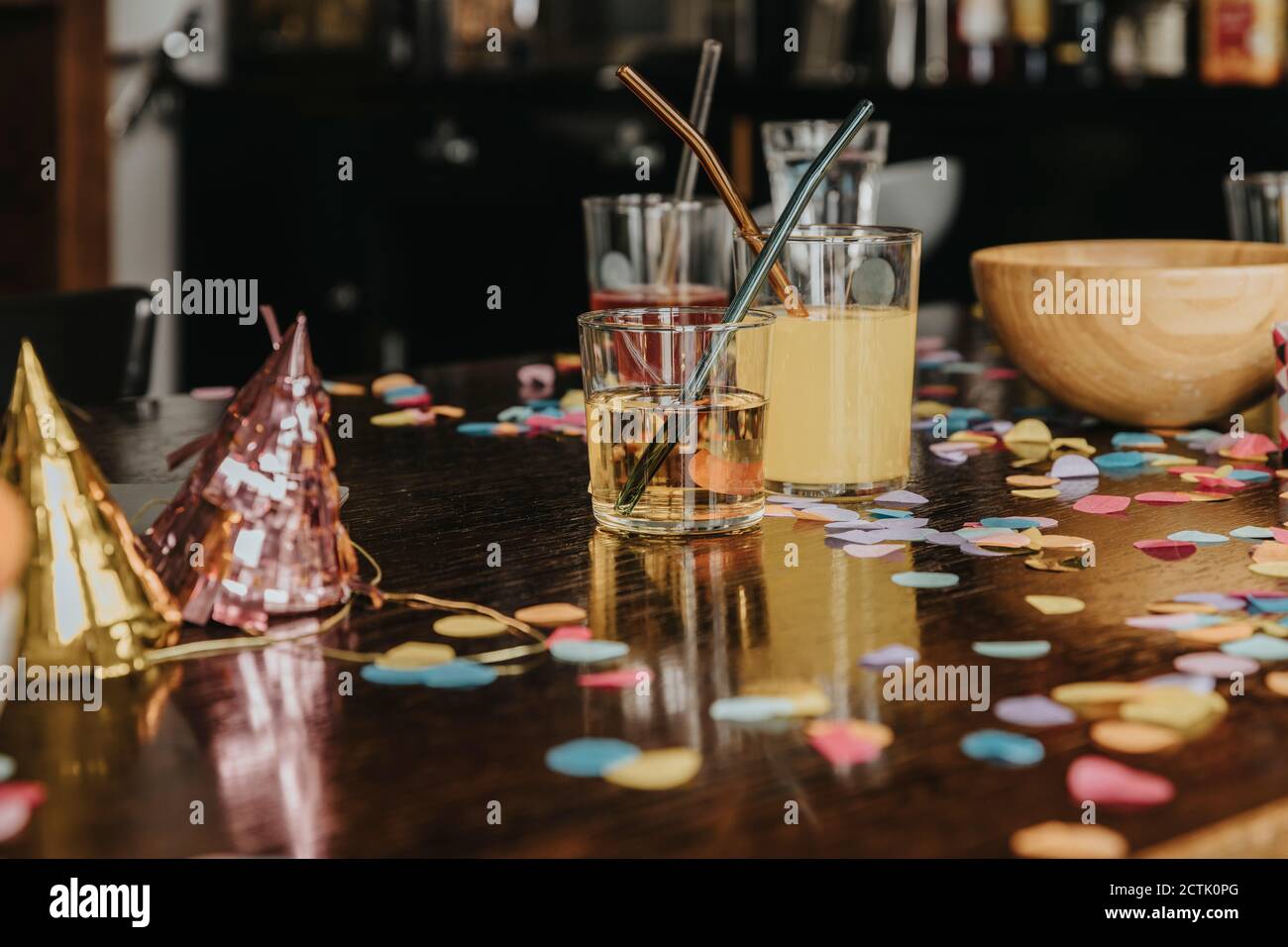 Close-up of drinks with party hats and confetti on dining table at home Stock Photo