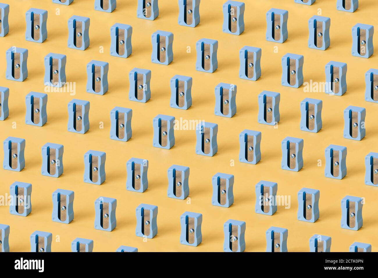 Blue pencil sharpeners against yellow background Stock Photo