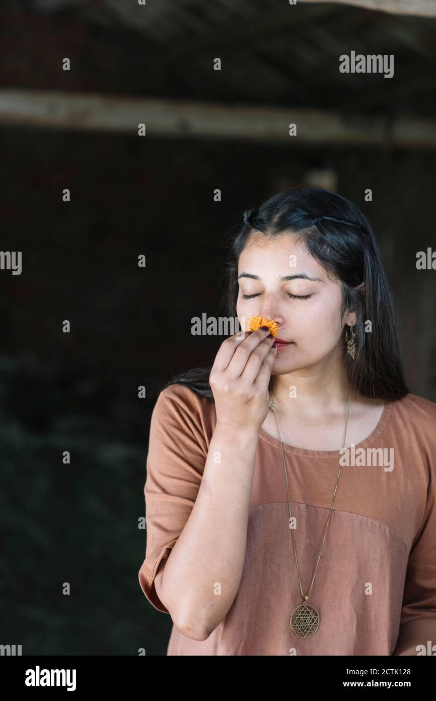 Beautiful woman smelling fresh orange flower Stock Photo