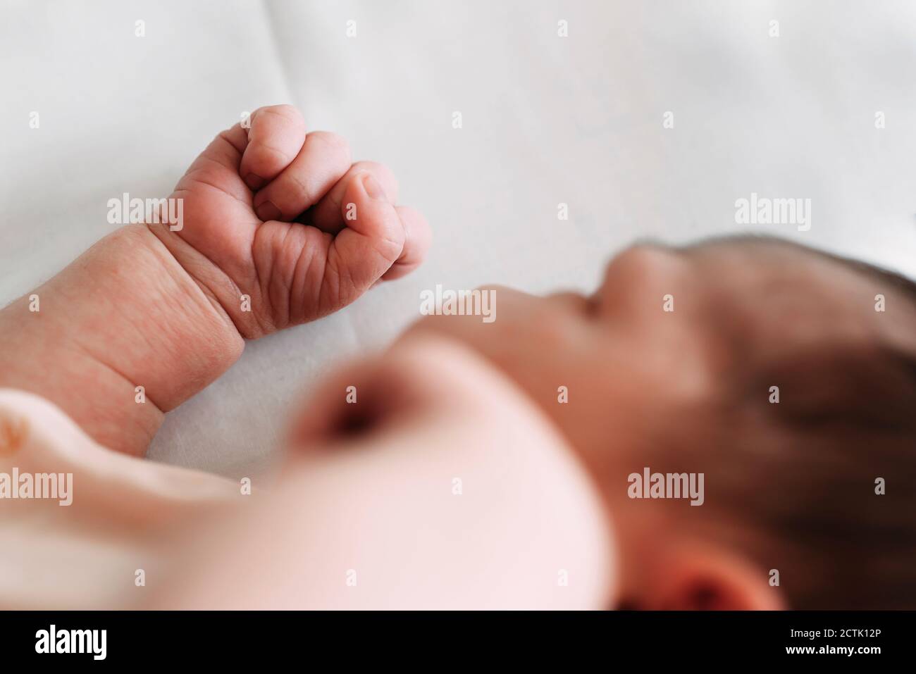 Close-up of newborn baby girl lying on bed in hospital Stock Photo