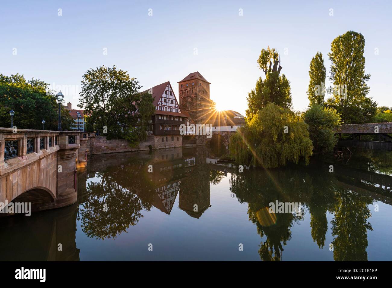 Germany, Bavaria, Nuremberg, Weinstadel and Wasserturm reflecting in river Pegnitz at sunset Stock Photo