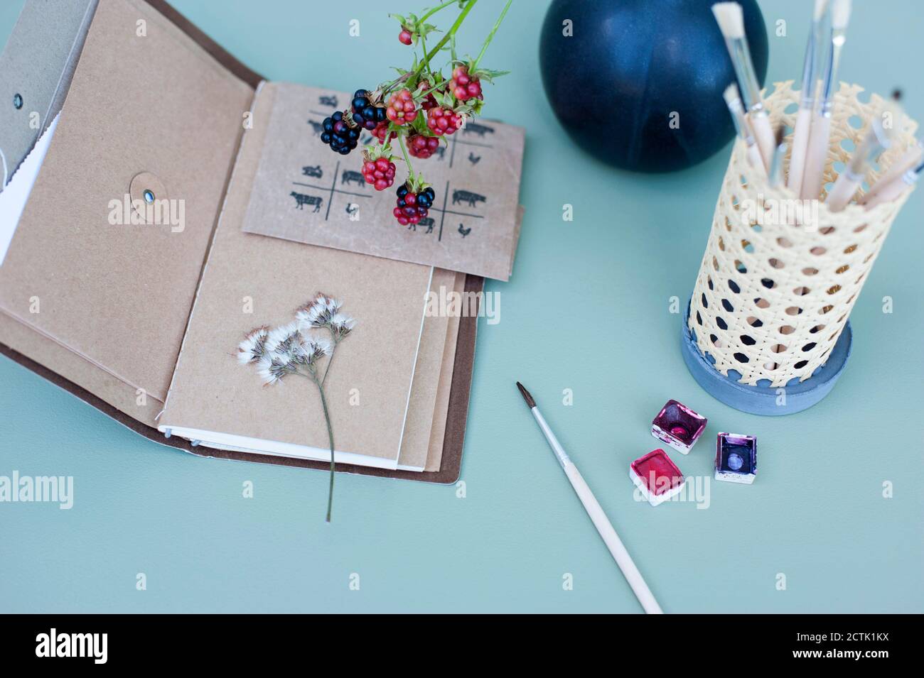 Watercolor Paints Dried Flowers Note Pad And Diy Rattan Desk Organizer With Paintbrushes Stock Photo Alamy